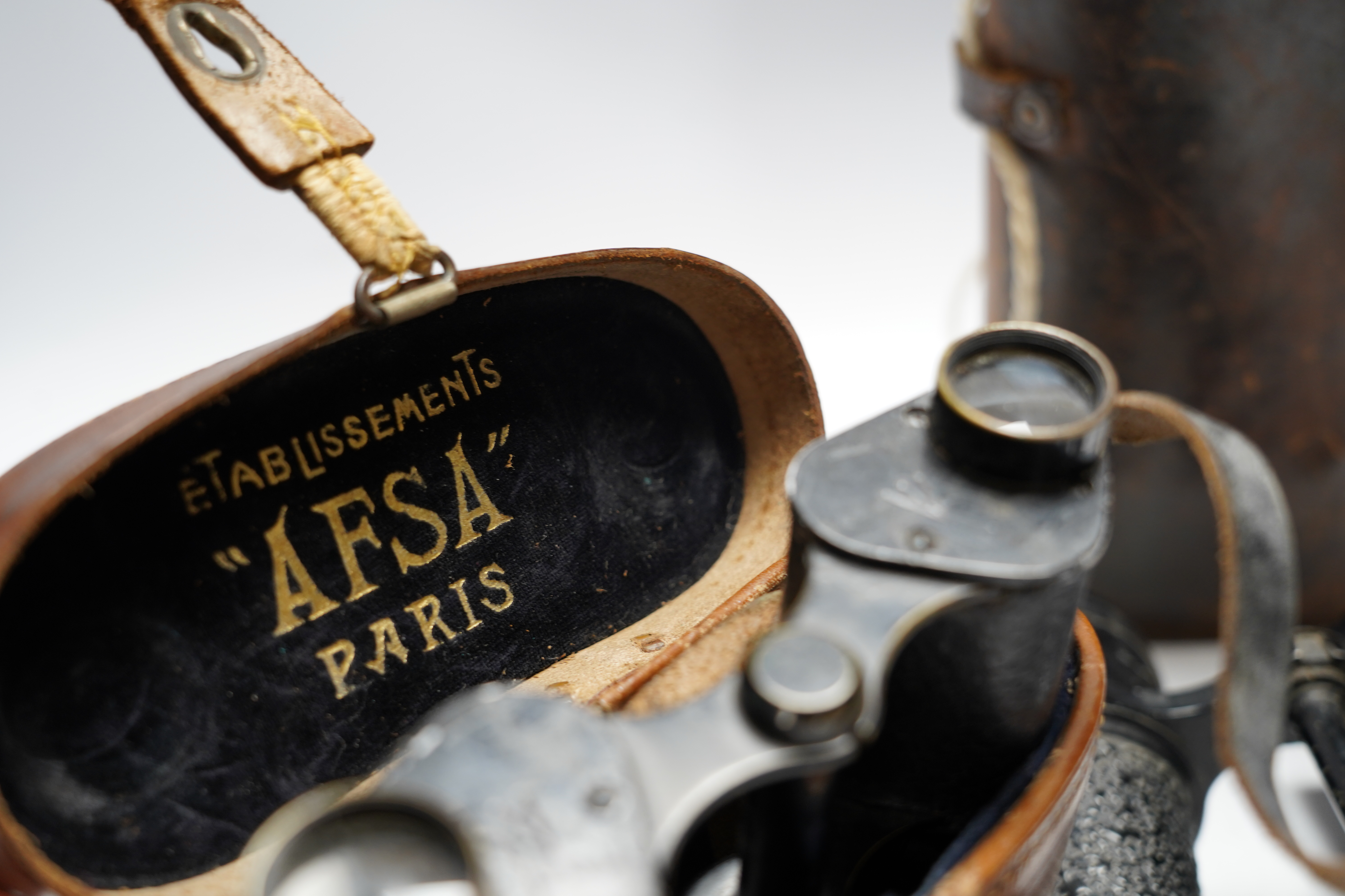 Two cased pairs of binoculars and a brass bugle.